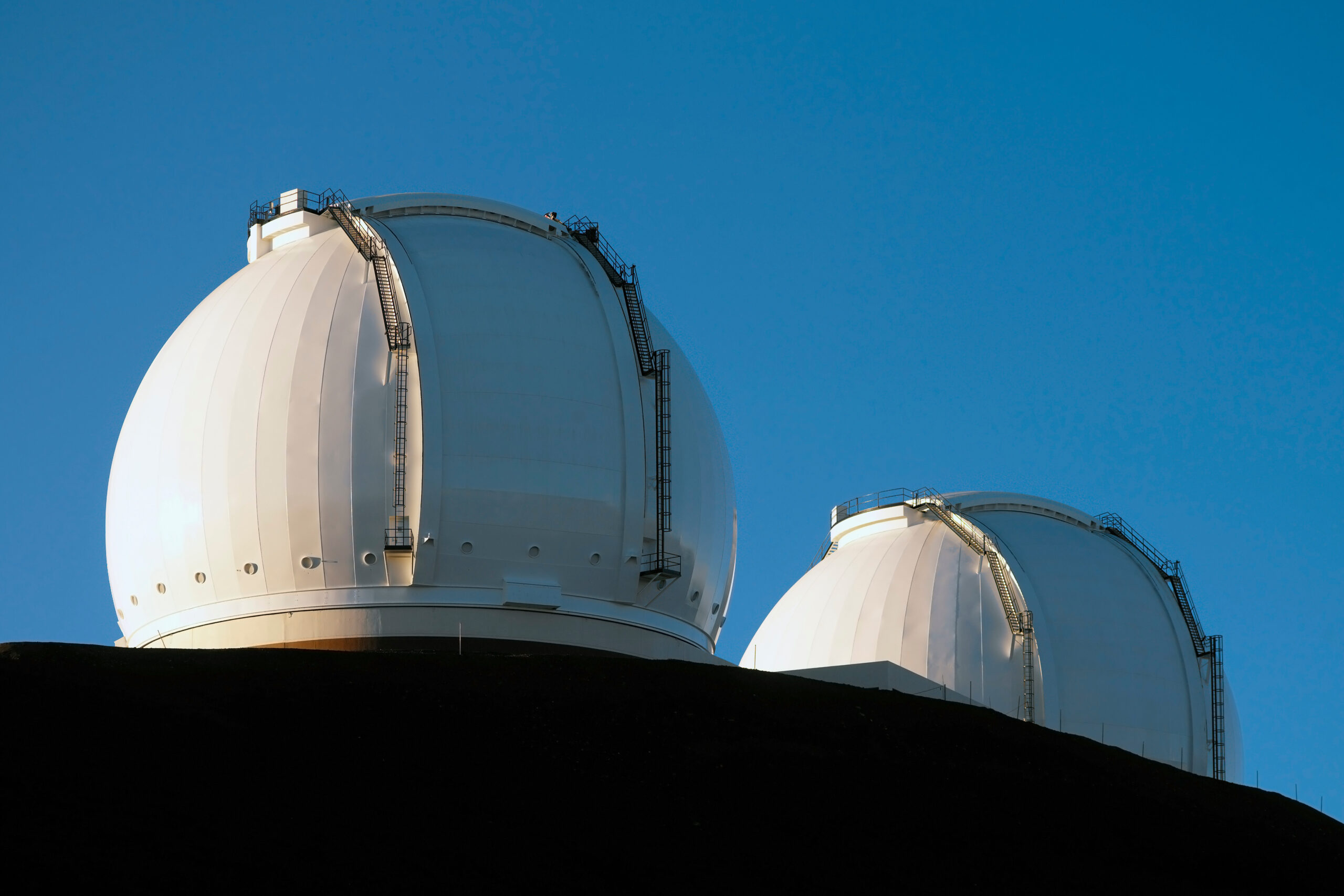 The Mauna Kea Observatories are a collection of astronomical research facilities located on the summit of Mauna Kea on the Big Island of Hawaii, USA. The location is ideal because of its dark skies, low humidity and position above most of the water vapor in the atmosphere, clean air, good weather and an almost equatorial location.