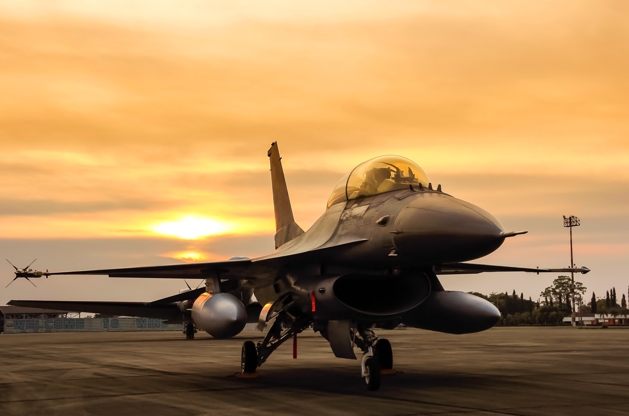 f16 falcon fighter jet on sunset  background